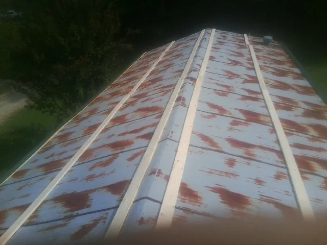 Rusted metal roof panels with new wood purlins before replacement — Storm Damage Roof Repair in Sapelo Island by Roofing Brothers