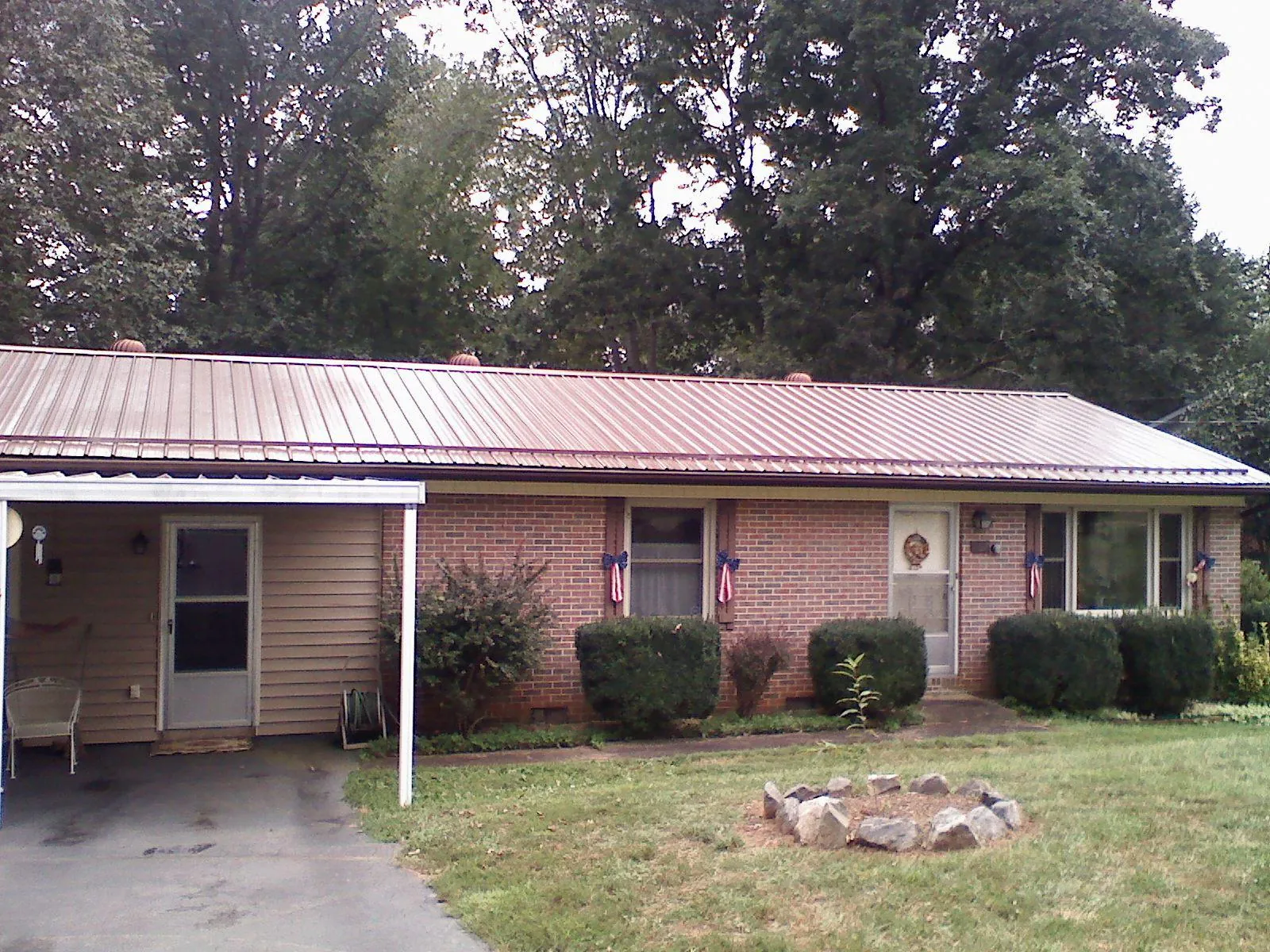 Bronze metal roof and carport on a brick ranch home — Roof Repair work by our crew in Sapelo Island